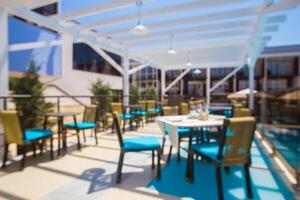 Outdoor dining area with vibrant furniture near a pool on a sunny day in a modern setting photo