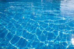 Bright blue swimming pool water reflecting sunlight creates a calm and inviting atmosphere in a sunny setting photo