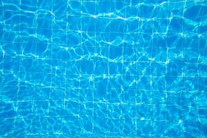 Clear blue water surface with captivating reflections in a swimming pool during a sunny day photo