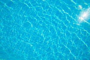 Clear water ripples create a serene atmosphere in a tiled pool under bright sunlight photo