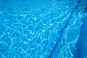 Sparkling turquoise water in a swimming pool on a sunny afternoon photo