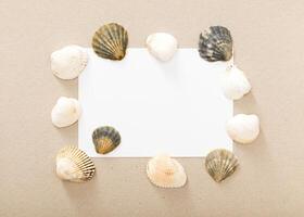 Unique arrangement of seashells framing a blank card on a neutral background for creative projects photo