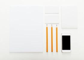 Desk workspace setup with stationery and smartphone on clean background photo