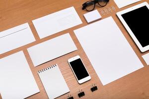 Office workspace with stationery items and digital devices arranged on wooden desk photo