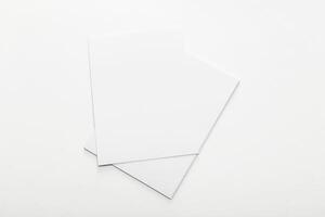 Blank sheets of paper stacked on a white surface, ready for creative projects and ideas creation in a minimalist workspace photo