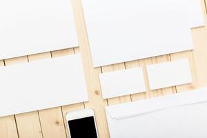 Minimalist stationery layout on wooden table with smartphone and envelopes arranged neatly photo