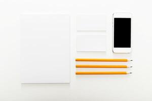 Workspace organized for creativity with stationery, smartphone, and blank notepads on a clean surface photo