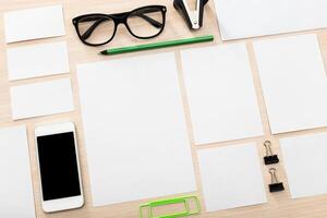 Office supplies arranged on a workspace with smartphone, glasses, and stationery items in a neat layout photo