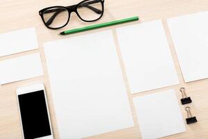Blank workspace layout with stationery and smartphone on wooden desk for creative planning and organization photo
