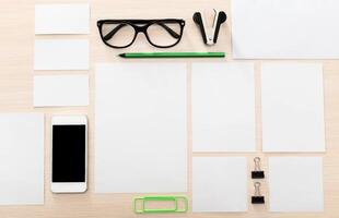 Office workspace with stationery and mobile device on a wooden desk in a well-lit environment ideal for productivity photo