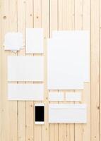 Blank stationery and smartphone arranged on wooden table for design or branding projects photo