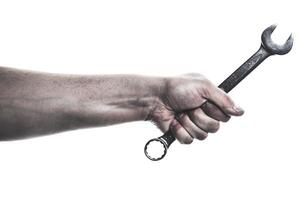 Hand holds a wrench ready for mechanical work in an industrial setting photo
