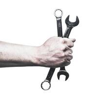 Skilled hands hold wrenches ready for mechanical maintenance and repair tasks in a workshop setting photo
