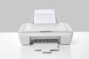 Modern desktop printer with printed paper ready for collection on a clean table surface photo