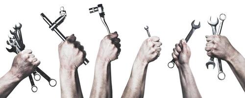 Hand holding various wrenches ready for mechanical work in a neutral background setting photo