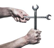 Hands gripping two wrenches, forming a cross, highlighting tools and craftsmanship in a creative way photo