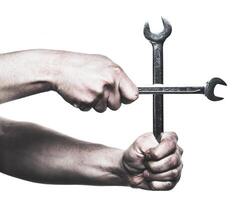 Hand gripping crossed wrenches demonstrating a combination of strength and skill in mechanical tasks photo