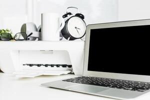 Workspace with laptop and printer in modern office setting, showcasing productivity essentials in a clean environment photo