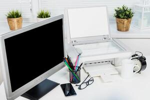 Office workspace with a computer monitor, printer, and stationery set during a morning routine photo