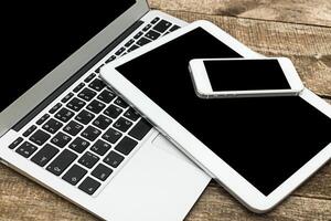 Digital devices arranged on wooden surface showcasing technology and connectivity in a modern workspace environment photo