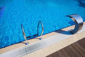Sunny outdoor swimming pool with modern design and stylish entrance steps photo