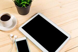 Technology and relaxation setup on a wooden table with coffee, tablet, and smartphone photo