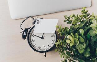 Time management tools on a desk with a clock and a small plant reminding of productivity and organization at work photo