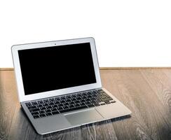 Silver laptop placed on wooden surface with blank screen, suggesting potential for productivity or creativity photo