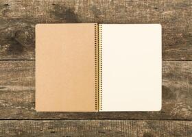 Blank spiral notebook placed on rustic wooden table for creative writing and brainstorming activities photo