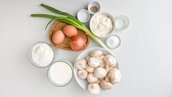 Assorted fresh ingredients including eggs, mushrooms, and dairy products are neatly arranged, ideal for cooking or Easter recipes photo