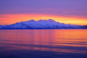 Stunning sunset over snow-capped mountain range photo