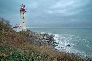 Lighthouse shining on a rocky coast during a cloudy day photo
