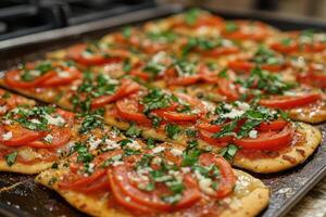 Delicious flatbread pizzas baking on a tray, featuring fresh tomatoes, basil, and feta cheese photo
