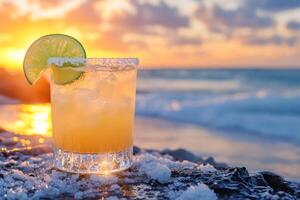 Margarita cocktail is standing on a rock at sunset on the beach photo