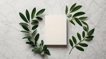 Elegant White Invitation Card with Greenery Frame on Marble photo