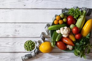 Diet plan, menu or program, water, dumbbells and diet food from fresh fruits on a white background, the concept of weight loss and detoxification, top view photo