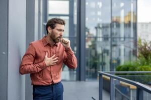 Mature man coughing with visible discomfort. Indicates possible respiratory issues or illness symptoms. Health concept, concern visible on face. photo