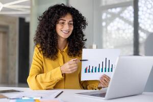 Online business presentation conference. Woman happily smiling showing sharing financial investment report, graph with charts. Businesswoman at workplace using notebook for call. photo