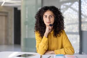Serious woman with headset looking at camera. Web camera view, online business meeting conference. Support service worker, customer service consulting. photo