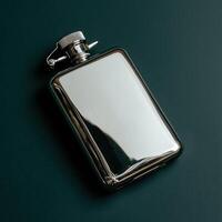A shiny metal hip flask on a dark green background photo