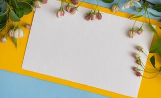 Floral layout on a vintage white wooden background and computer partially. Spring flowers, woman freelancing concept. View from above. photo