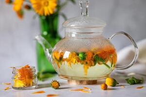 The elements in the image, including the thermometer and flower-infused tea, hint at a soothing and healing process photo