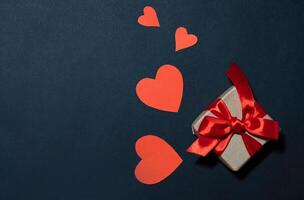 Red hearts and craft gifts on a white wooden background. Copy space. photo