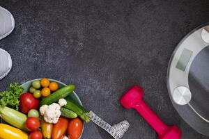 Diet plan, menu or program, roulette, water, dumbbells and diet food from fresh fruits on a black background, the concept of weight loss and detoxification, top view photo