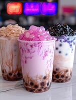 Three bubble tea drinks with different flavored toppings photo