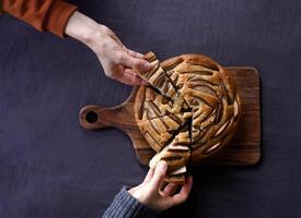 Hands taking pieces of a pie dark background copy space photo