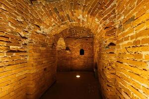 Red brick underground tunnel under old fortress. photo