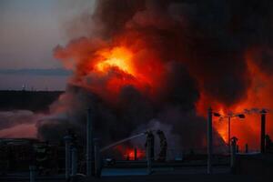 Firefighters extinguish burning industrial building in city photo