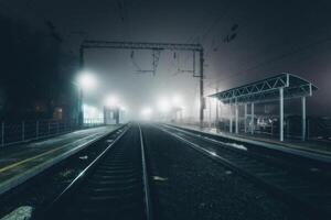 Foggy railway station, railroad track in the fog photo