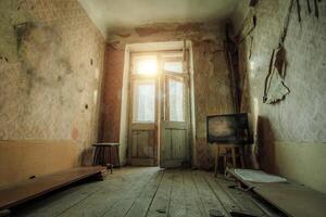 Creepy broken television in dirty room of abandoned house photo